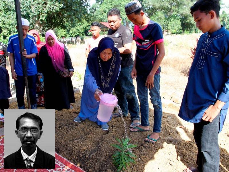 Hatipah Manap merenjis pusara suaminya, jurukamera Bernama News Channel (BNC) Allahyarham Mohammad Ariffin, 62, di Tanah Perkuburan Islam Kampung Senduk, Batu 8 Bendang Siam, Changkat Jering selepas solat Zuhur, hari ini. - Foto: Bernama
