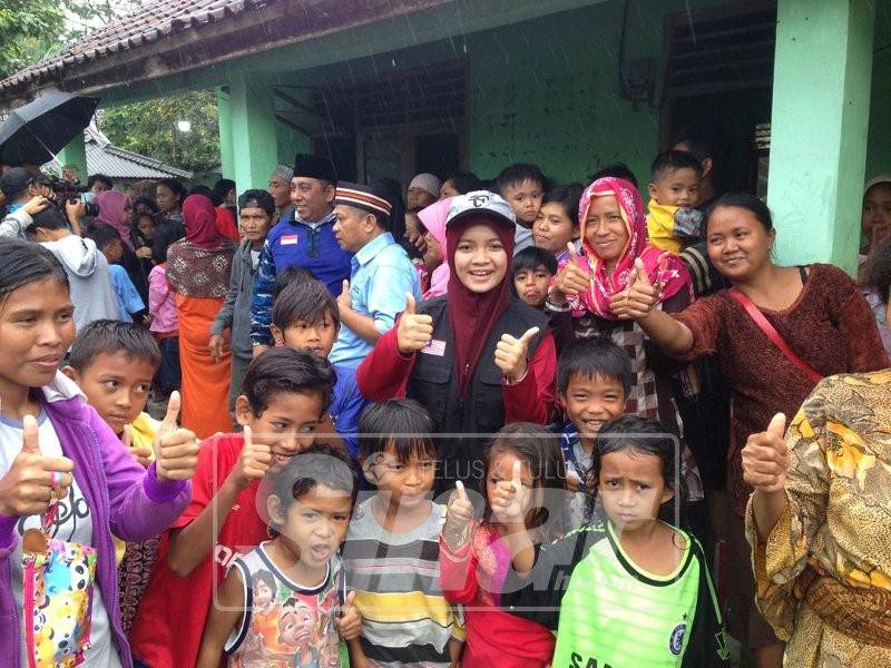 Anak-anak yang berlindung di sekolah agama Desa Caringin ceria menerima kehadiran sukarelawan Serantau Muslim.