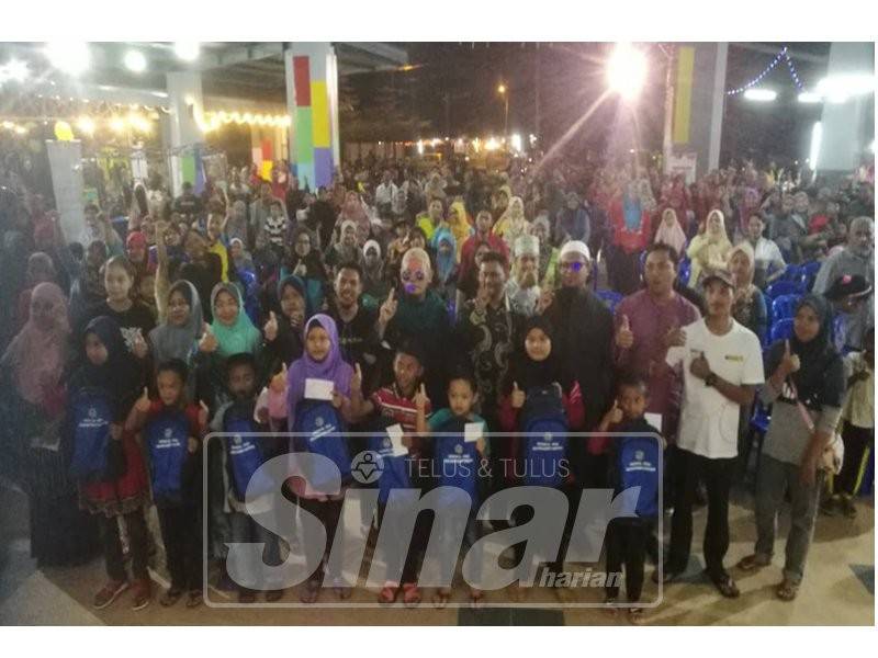 Syed Abu Talib (tengah) mewakili Syed Abu Hussin menyerahkan sumbangan zakat Kembali Ke Sekolah Parlimen Bukit Gantang kepada 170 pelajar asnaf di Laman Changkat Jering yang baru kembali beroperasi malam tadi.