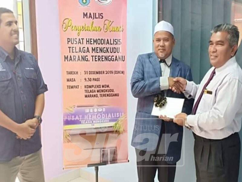 Ariffin menyerahkan kunci kepada Mohd (kanan) di Majlis Penyerahan Kunci Pusat Hemodialisis Telaga Mengkudu.