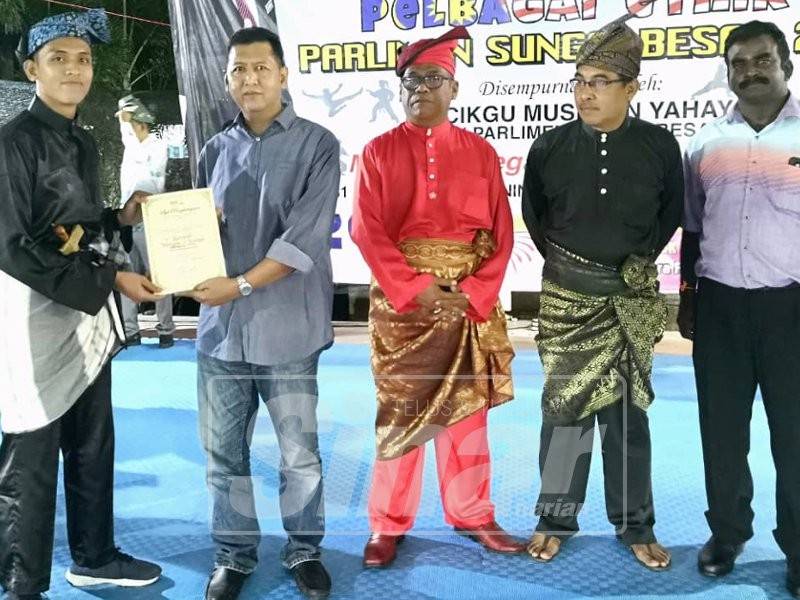 Azhar (dua kiri) menyampaikan sijil penghargaan kepada salah seorang wakil peserta pada Karnival Warisan dan Budaya Pelbagai Etnik Parlimen Sungai Besar di Dataran Tonggak 10, di sini.