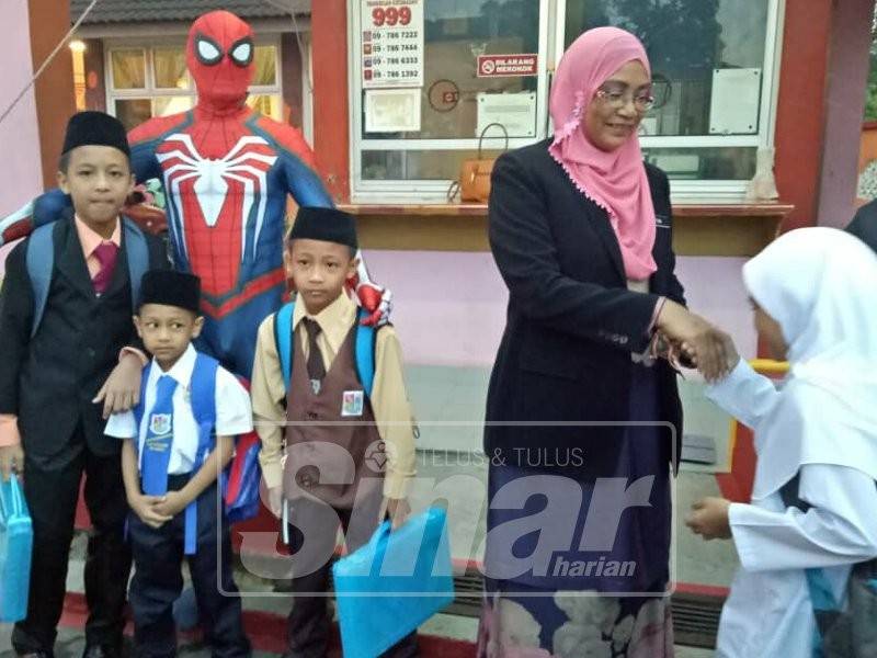 Zaiton bersama Spiderman menyambut kedatangan murid pada hari pertama sesi persekolahan 2019.
