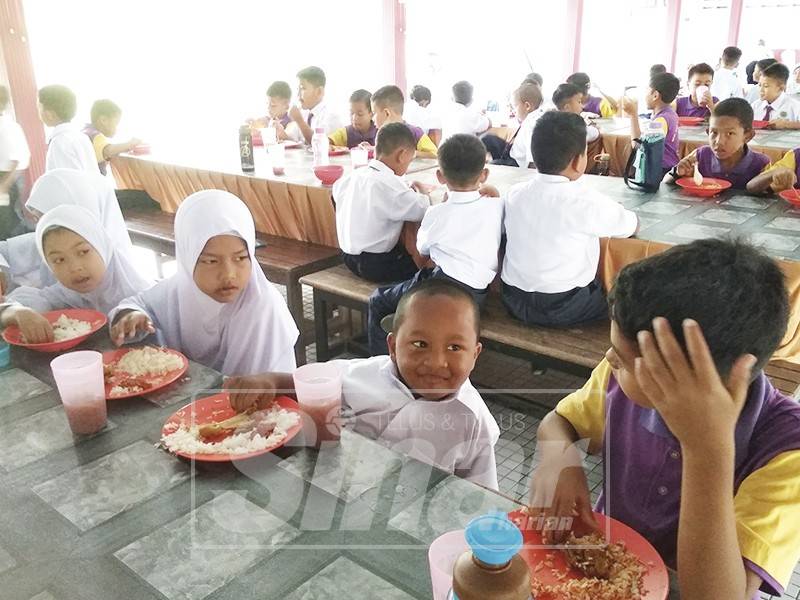 Amsyar makan bersama rakan di kantin sekolah.