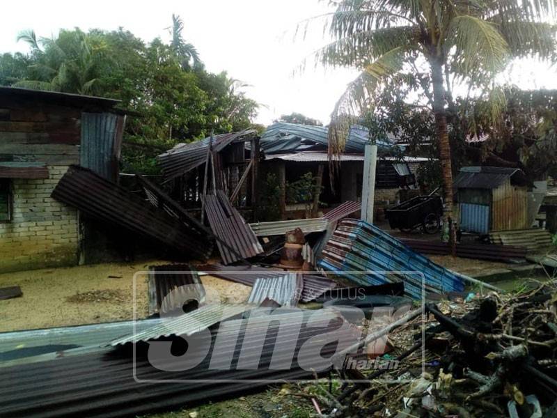 Noordin(kiri) meninjau keadaan bumbung salah sebuah rumah mangsa ribut di Kampung PPMS Bukit Merah yang diterbalikkan sepenuhnya ribut petang tadi.