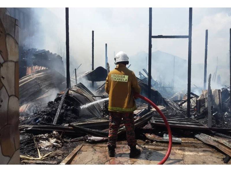 Anggota Bomba dan Penyelamat memadamkan kebakaran rumah di Kampung Cheras Baru.
