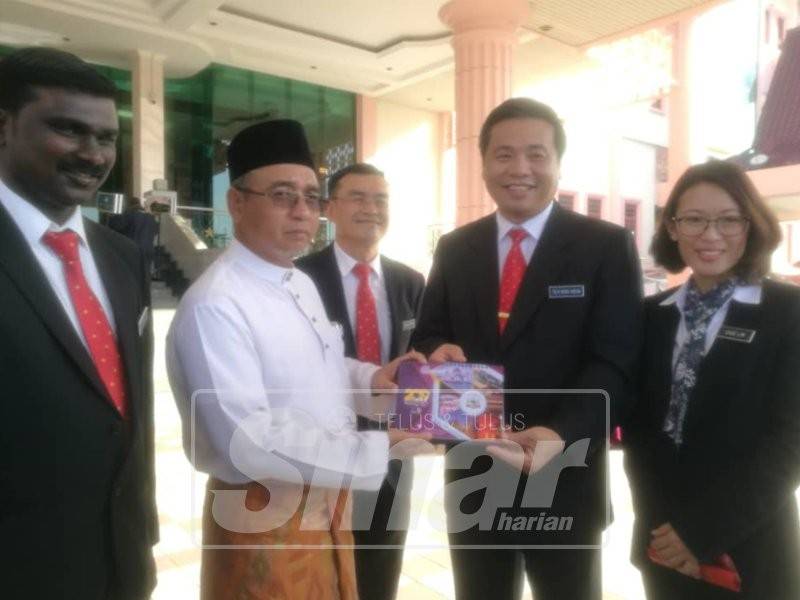 Adly serah kalendar kerajaan negeri kepada Exco Perumahan, Kerajaan Tempatan, Alam Sekitar dan Teknologi Hijau, Datuk Tey Kok Kiew selepas majlis perhimpunan bulanan di Dataran Seri Negeri di sini, semalam.