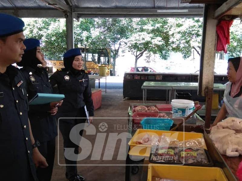 Ketua operasi, Fazuri Ramli (kiri) bersama anggotanya sedang menyoal salah seorang peniaga di situ ketika membuat pemeriksaan hari ini.