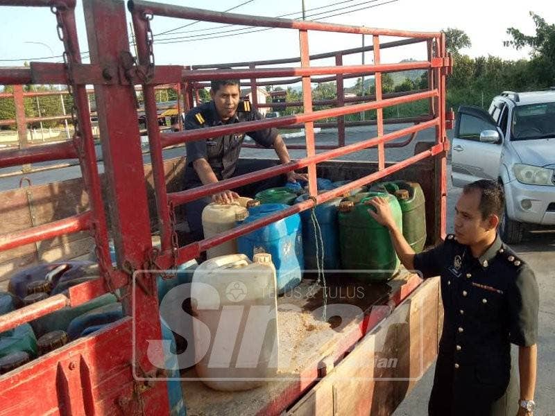 Pegawai dan anggota KPNKHEP memeriksa setiap tong berisi diesel yang dirampas.