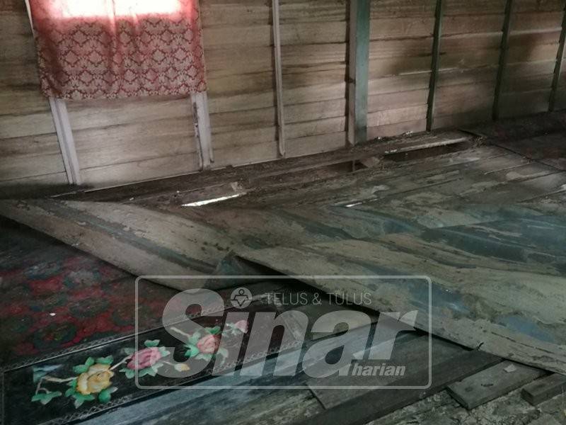 Sebahagian lantai rumah menunggu masa untuk runtuh kerana papan sudah reput.