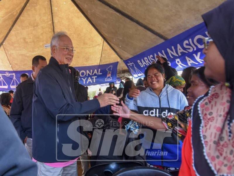 Najib dan Ramli mengambil kesempatan mendekati penduduk di perkampungan orang asli moden, Kg Sungai Ruil, pagi ini. Foto: SHARIFUDIN ABDUL RAHIM.	