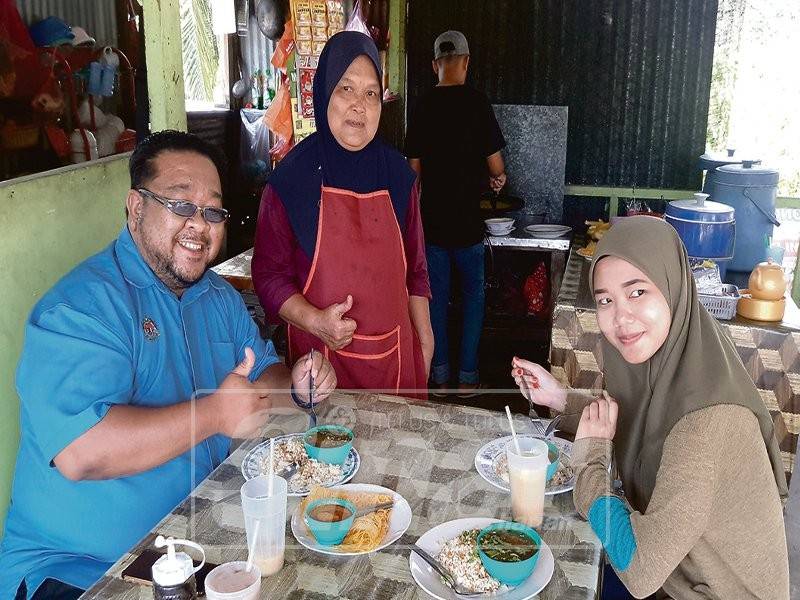 Makyang melayan pelanggan yang menjamu selera di kedainya.
