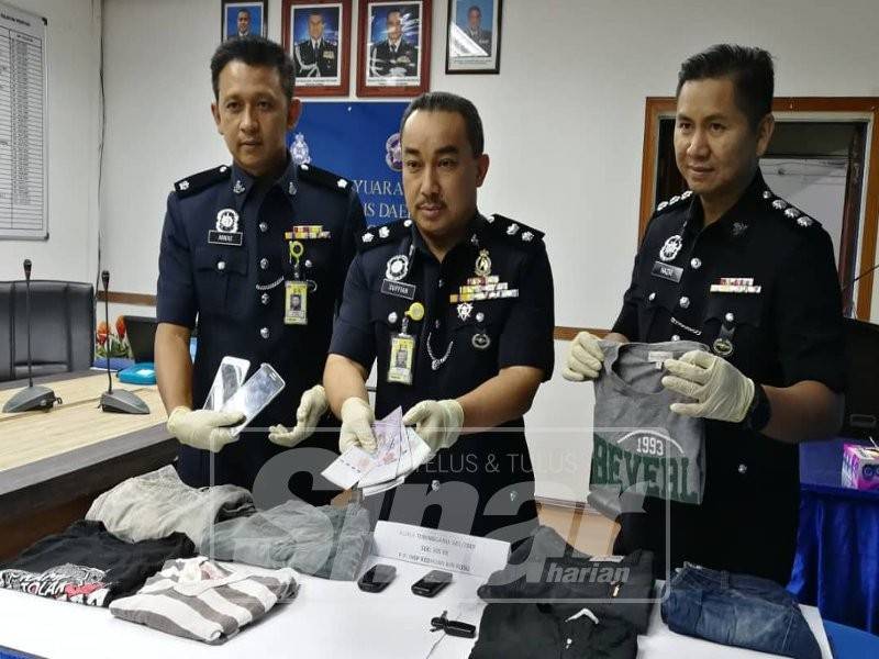 Suffian (tengah) dan pegawainya menunjukkan sebahagian daripada barangan yang dirampas.