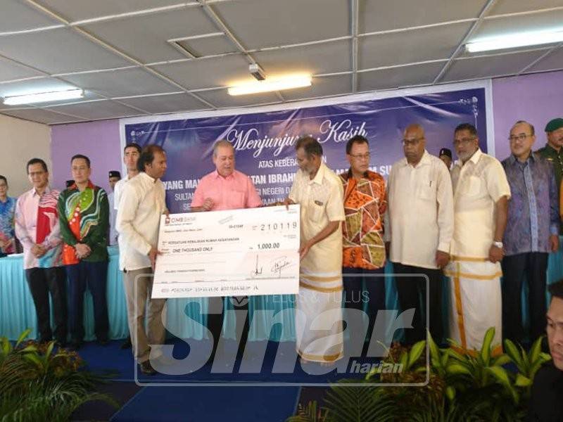 Sultan Ibrahim berkenan menyampaikan sumbangan daripada pihak kuil kepada para penerima.