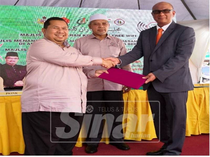 Ahmad (tengah) menyaksikan pertukaran dokumen kerjasama antara PKINK dan TM di Dataran Ilmu hari ini.