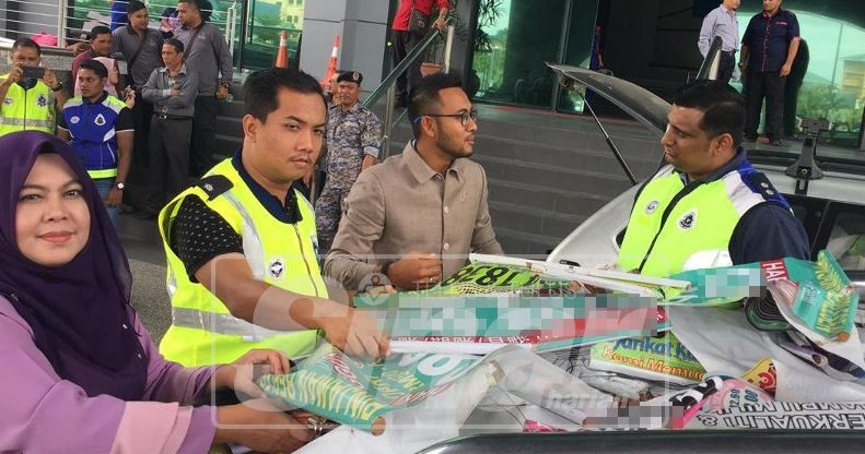 Nor Kamawati (kiri, depan) bersama Alias dan anggota perlesenan MPK serta pihak polis menurunkan gegantung dan iklan yang diturunkan dalam operasi itu