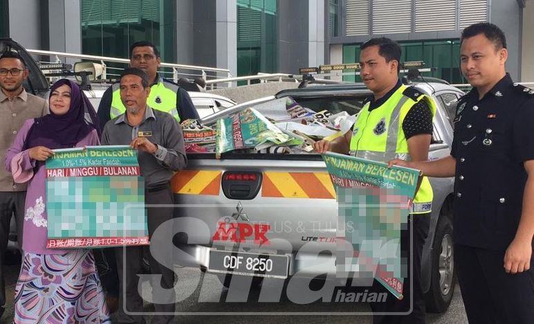 Nor Kamawati melihat gegantung dan iklan haram yang diturunkan dalam operasi pagi tadi.
