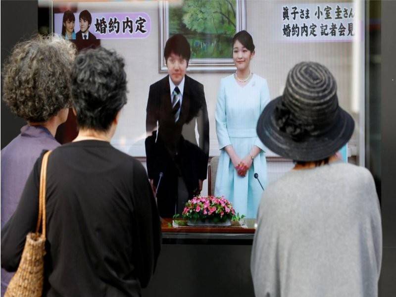 Orang ramai menonton paparan televisyen yang menyiarkan pengumuman pertunangan Komura dan Puteri Mako pada September 2017.
