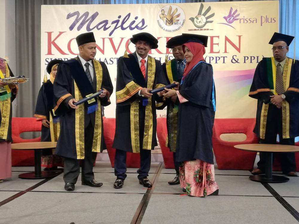 MOHD SHAID (dua dari kiri) dan Jamil (kanan) menyampaikan skrol kepada para graduan.