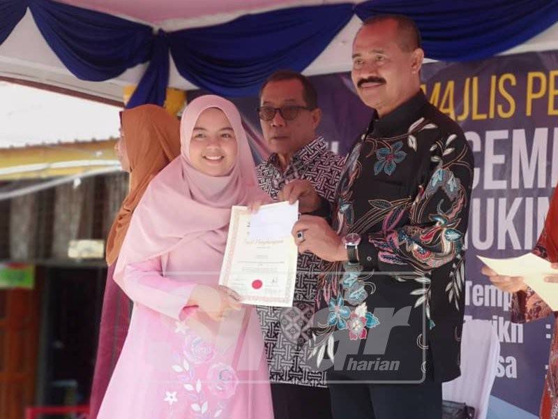 Abu Bakar Yahya menyampaikan penyampaian sijil kepada salah seorang daripada 185 pelajar dalam Program Anugerah Kecemerlangan UPSR 2018 Mukim Beranang di SK Kampung Rinching, Semenyih pagi ini.