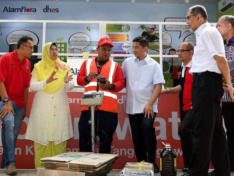 Menteri Perumahan dan Kerajaan Tempatan Zuraida Kamaruddin mendengar penerangan daripada pekerja Alam Flora Bahagian Kitar Semula, Azrul Mohamad pada Pelancaran ‘3R On Wheels’ & Kad Mesra di Stesen Minyak Petronas Jalan Kolam Ayer hari ini. Foto: Bernama
