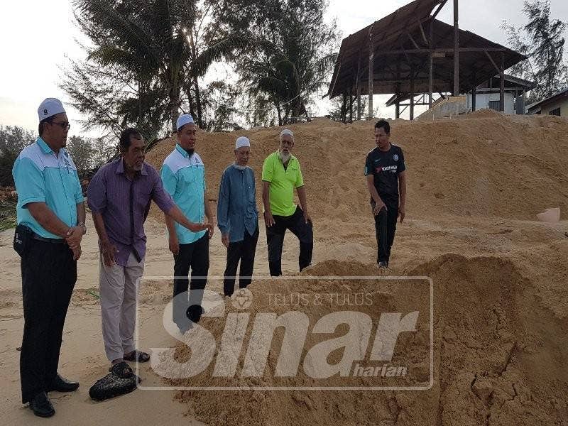 Saiful Azmi (tiga, kanan) bersama pimpinan MPKK Pekan Kemasik dan nelayan meninjau kerja-kerja menambak hakisan.
