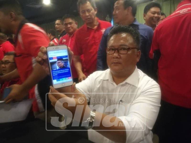 Zamzuri menunjukkan laporan portal berita yang mendakwa fitnah dan berniat jahat ketika sidang media berkenaan.