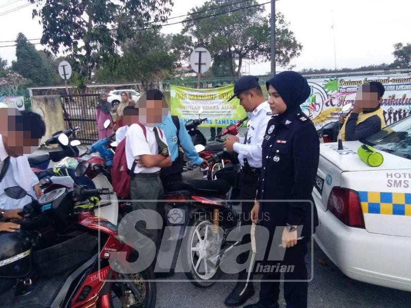 Anggota polis melakukan pemeriksaan terhadap pelajar sekolah di salah sebuah sekolah di sini, hari ini.
