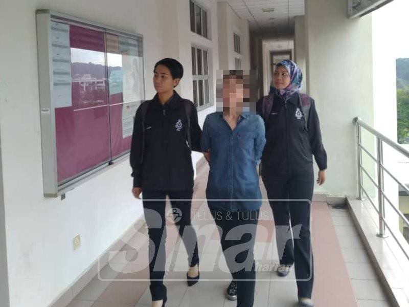 Lin San diiringi pegawai polis pada prosiding kes hari ini
