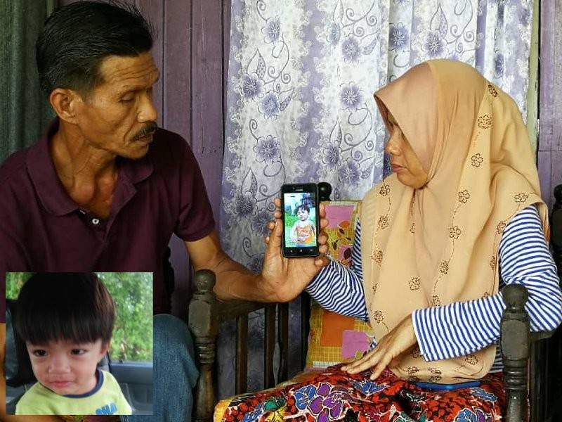 Nor Azizah dan suaminya, Wahab Ahmad, 55, kelihatan sayu menunjukkan gambar Muhammad Alif.