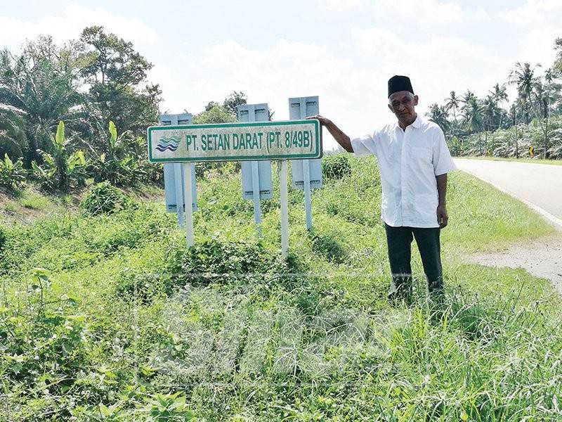Hasaan menunjukkan papan tanda yang masih menggunakan nama Parit Setan.