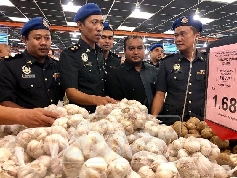 Azanizam (dua, kiri) meninjau harga barang di Pasaraya Pantai Timor Pengkalan Chepa hari ini.