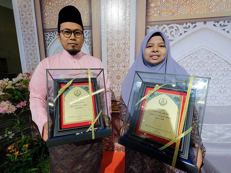  Johan Tilawah kategori Qari dan Qariah, Mohd Kamaruzaman Daud dan Nor Hazira Nabila Mohd Kamel bergambar bersama pada Majlis Penutup dan Penyampaian Hadiah Tilawah dan Menghafaz Al-Quran Peringkat Negeri Perak Darul Ridzuan Tahun 1440H/2019M malam ini. - Foto Bernama