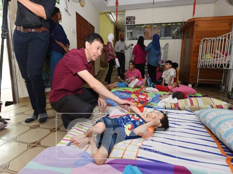 Danny beramah mesra dengan seorang anak istimewa ketika lawatan.