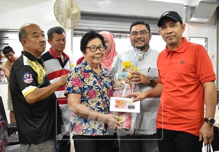 Abdul Yunus(kanan) dan Mujahid(dua kanan) berkesempatan menyerahkan sumbangan Tahun Baharu Cina kepada sebahagian warga emas masyarakat cina di sekitar kawasan Pekan Tanjung Piandang, Parit Buntar.