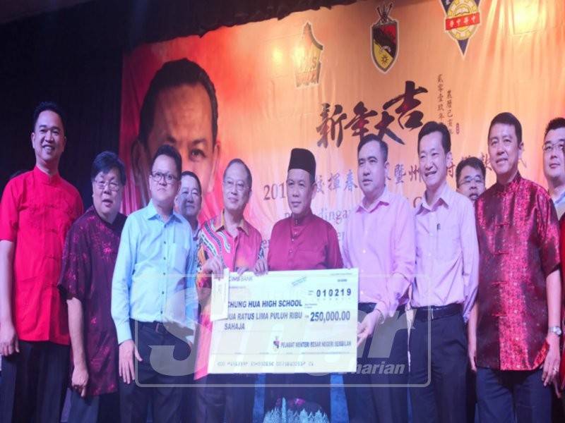Aminuddin (tengah) menyerahkan replika cek sumbangan kerajaan negeri kepada Sekolah Tinggi Chung Hua.
