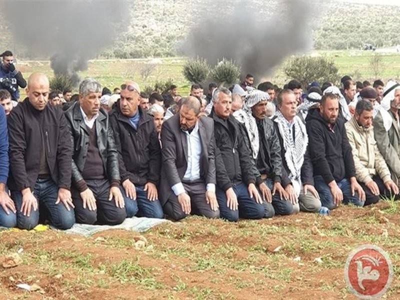 Penduduk kampung menunaikan solat Jumaat di kawasan terbuka.
