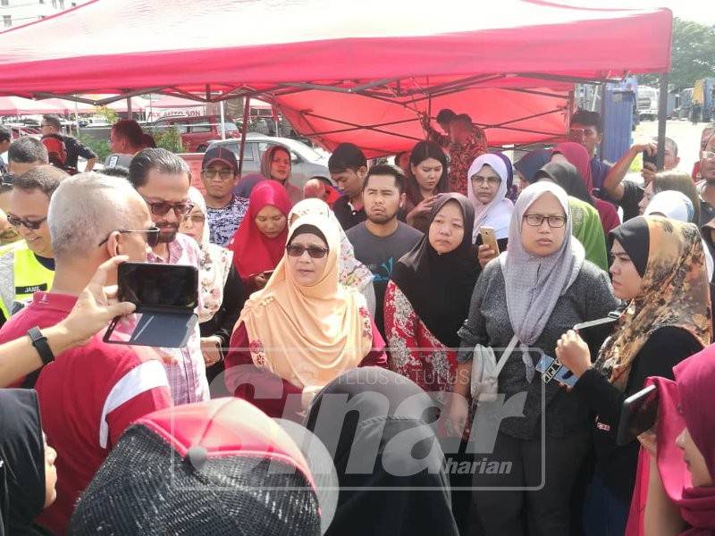 Siti Mariah (tengah) bertemu peniaga yang mengalami kerugian selepas gerai mereka di Puchong Permai terbakar.
