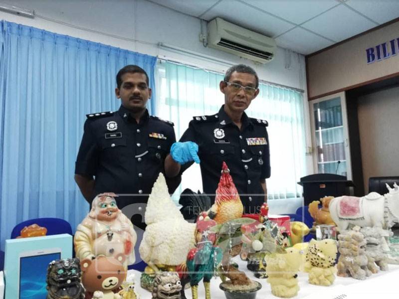 Mohad Idris menunjukkan peralatan sembahyang dirampas dalam serbuan di kediaman suspek.