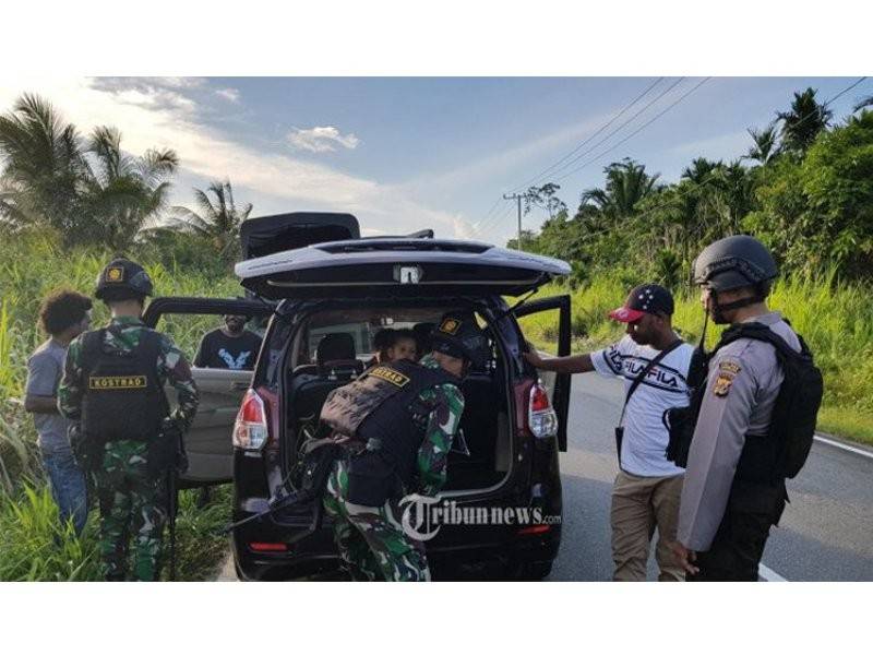 Polis Indonesia memeriksa sebuah kenderaan di sempadan Skouw, Papua.