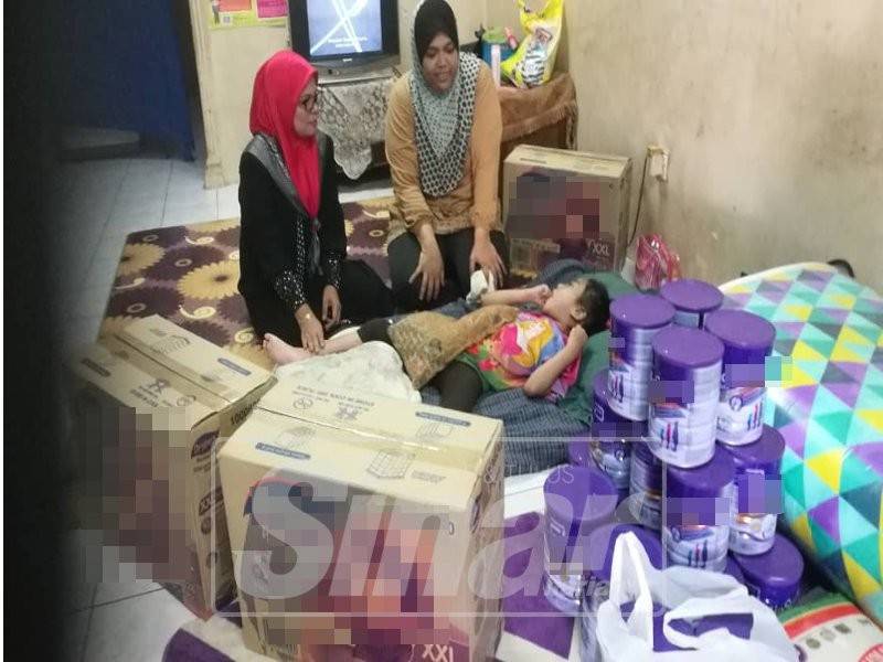 Haslizah (tengah) menjaga Adawiyyah yang terlantar di rumah akibat pelbagai penyakit kronik selain ketumbuhan otak.