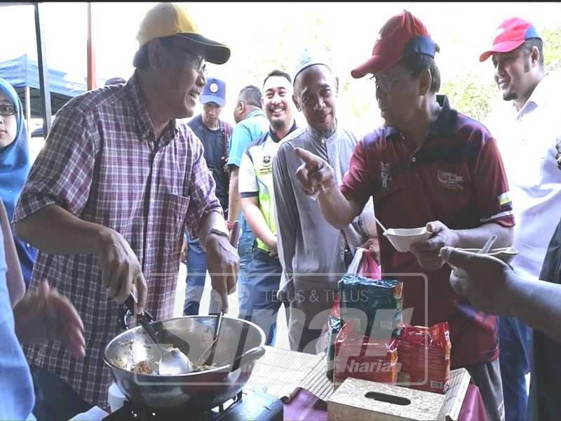 Basri (kiri) dan Asmuni sempat mencuba hidangan yang disediakan di pasar tani berkenaan.
