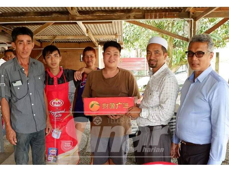 Sulaiman (kanan) menyampaikan sumbangan buah limau sempena sambutan Tahun Baharu Cina.