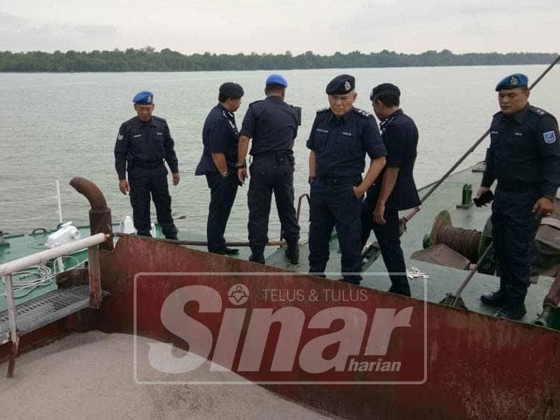 Acryl Sani (dua, kanan) melihat pasir yang disedut kapal korek terbabit.