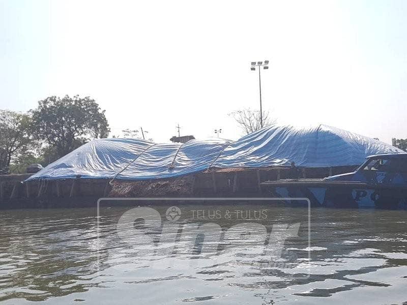 Sisa kacang soya yang ditutup dengan plastik dan diletakkan dalam tongkang di Jeti Sungai Perai.