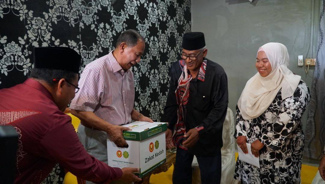 Sultan Sallehuddin berkenan menyerahkan sumbangan kit kotak makanan dari Lembaga Zakat Negeri Kedah (LZNK) kepada Jasni (dua kanan).
