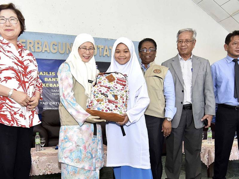 Timbalan Perdana Menteri Datuk Seri Dr Wan Azizah Wan Ismail (dua, kiri) menyampaikan bantuan beg sekolah kepada pelajar pada Majlis Penyerahan Wang Ihsan Bantuan Bencana Negara (Kebakaran) di Putatan dekat sini hari ini. - Foto Bernama