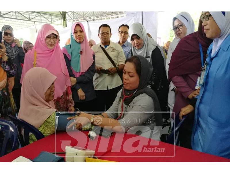 Nomee Ashikin memeriksa tekanan darah salah seorang wanita selepas merasmikan PAWE Kuala Kangsar.