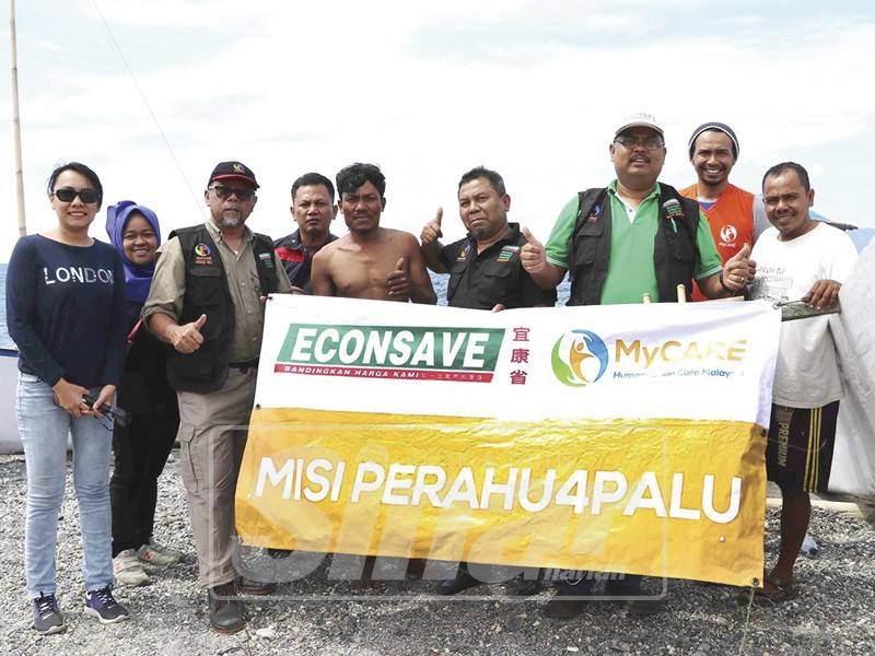 Mas Imran (baju hijau) menyerahkan sumbangan perahu kepada nelayan yang kerosakan bot ketika tsunami di Indonesia.