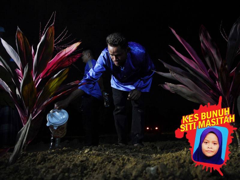 Bapa kanak-kanak dibunuh Ibrahim Ali,39, sugul ketika menyiram air ke pusara anaknya Siti Masitah Ibrahim,11, yang mati dibunuh dikebumikan di Tanah Perkuburan Islam Kampung Tanjung Medang, malam ini. - Foto Bernama