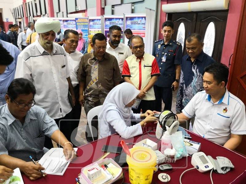 Kok Seong (duduk) berkesempatan membuat pemeriksaan kesihatan pada majlis itu.